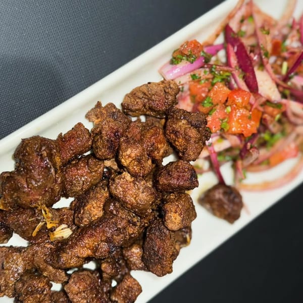 Elena's Greek Armenian Restaurant's fried liver with a side of red onion and tomato salad.